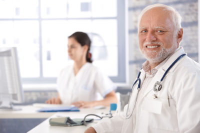 doctor sitting at desk smiling physician shortages